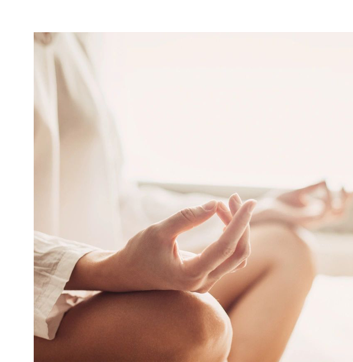 A person sitting in the middle of a yoga pose.