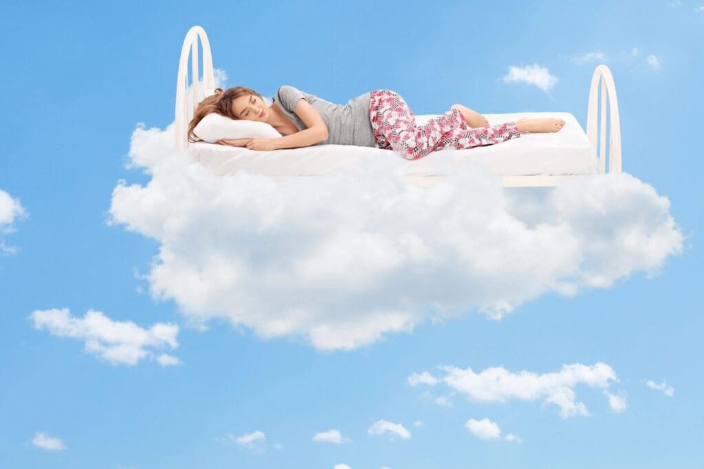 A woman laying on top of a cloud in the sky.