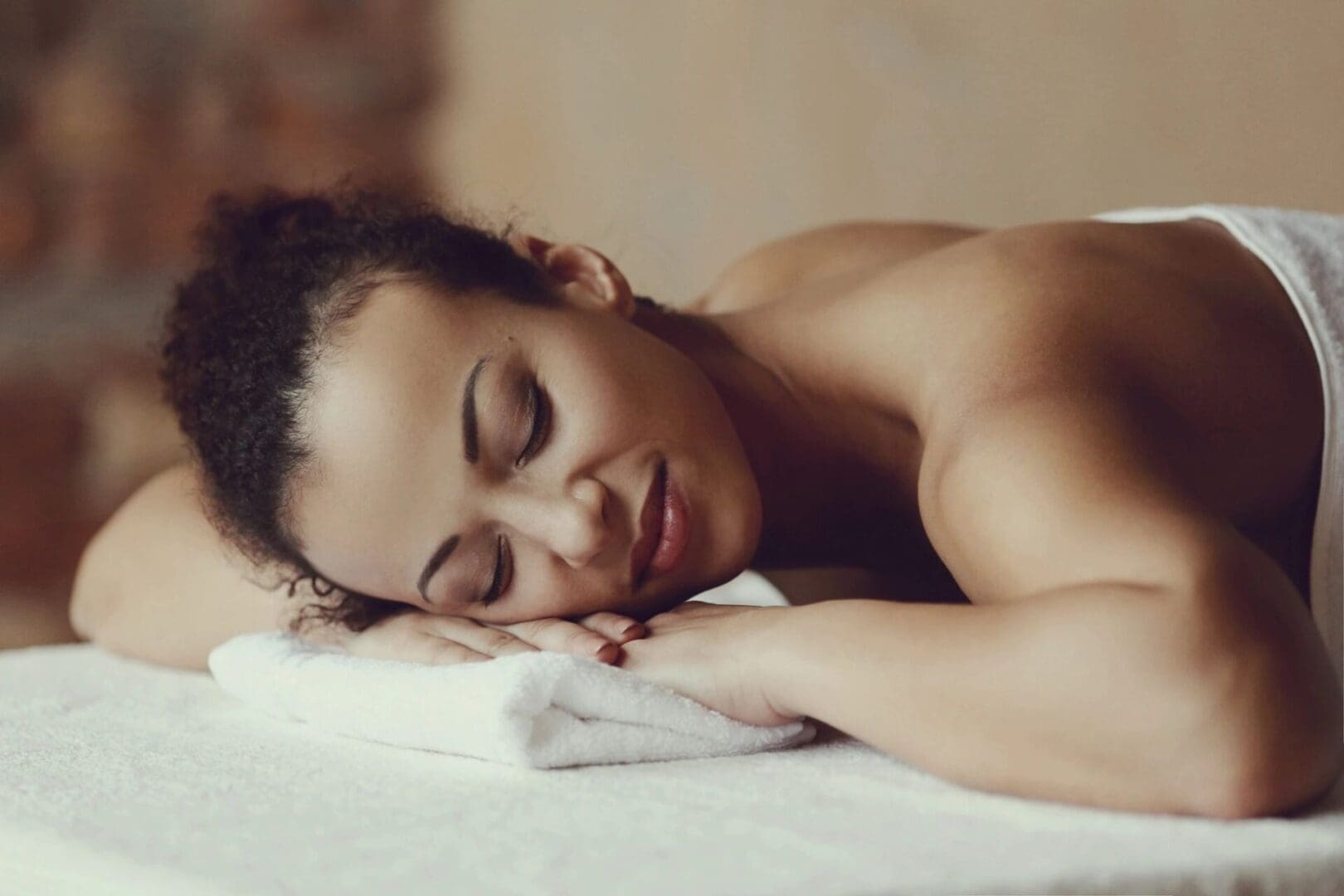 A woman laying on top of a towel.