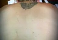 A man with tattoos on his back and neck.